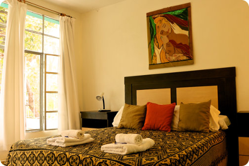 La foto muestra una de las luminosas habitaciones de la hosteria decorada por artistas del lugar.
