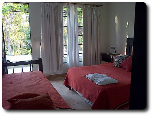 La foto muestra las comodidades que ofrecen las habitaciones para los huéspedes de la hostería, se puede apreciar el ambiente relajado y confortable.