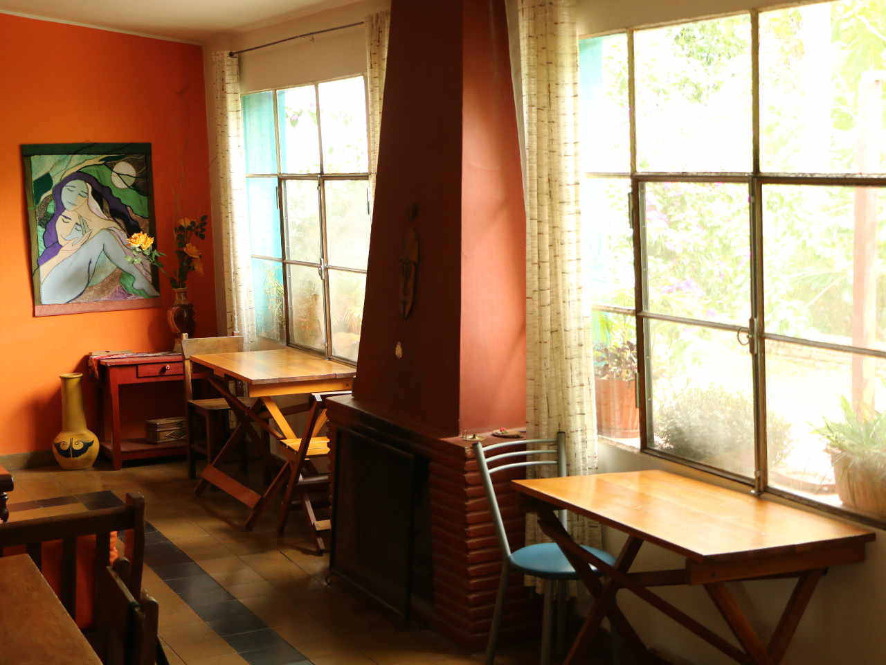 La foto muestra mesas y sillas en el desayunador de la hostería.